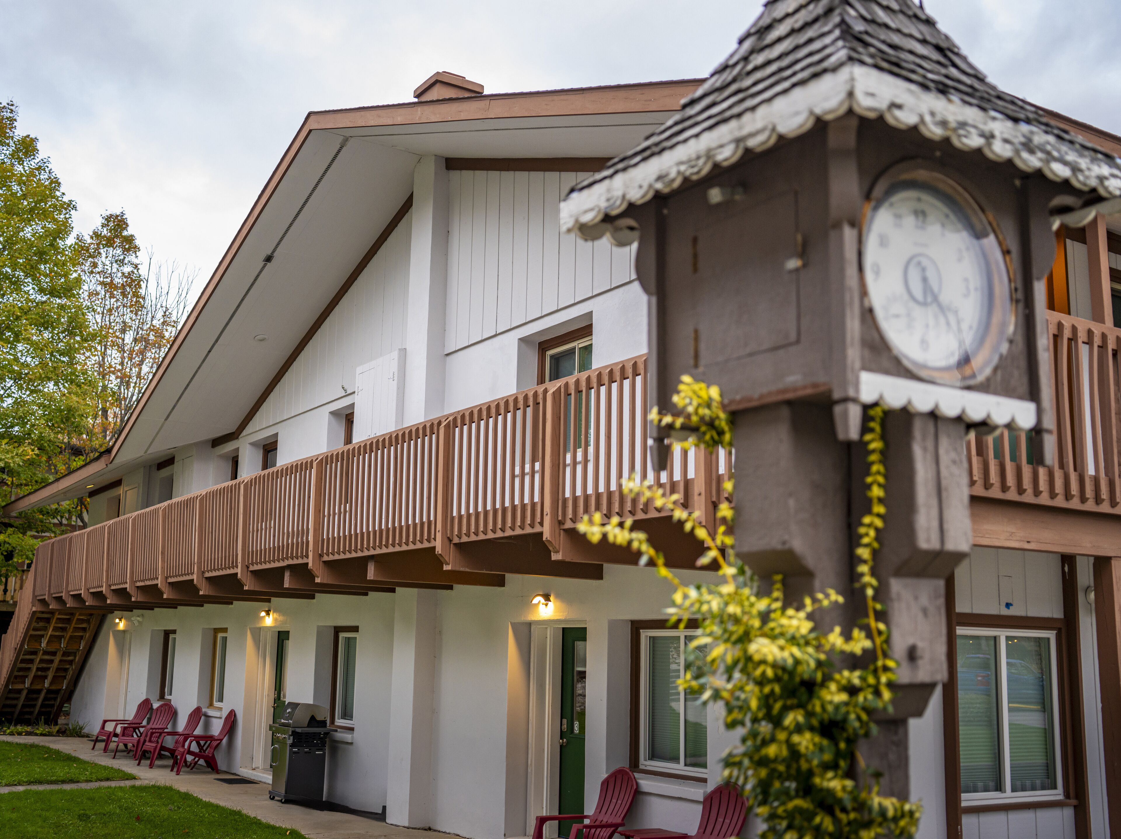 Ein zweistöckiges Gebäude mit Balkon und einer Turmuhr.