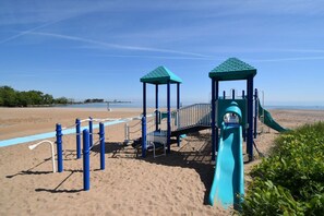 Ein Spielplatz am Strand mit Rutsche und Klettergerüsten.