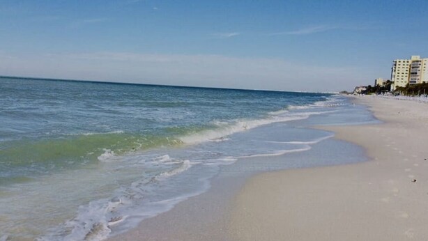 A beach with a sandy shore and a clear blue sky. - Cozy new construction townhome.  (Naples)