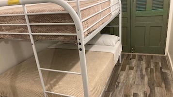 A bunk bed with a metal frame, two pillows, and a door in the background.