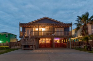 A two-story house with a balcony and a covered porch area.