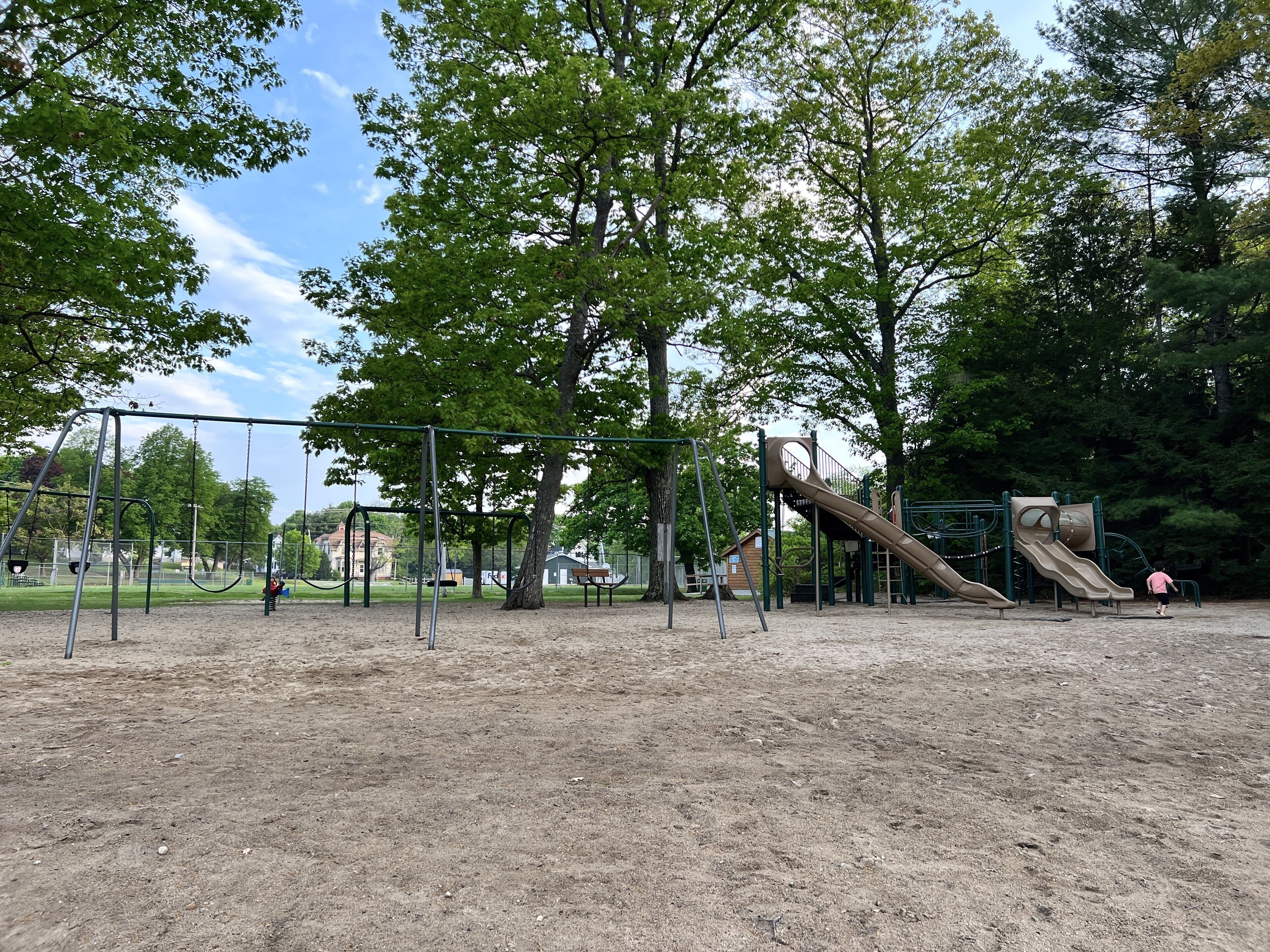A playground with swings, a slide, and a climbing structure.