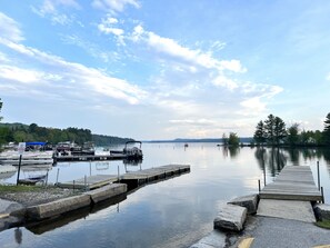 A calm lake with docked boats and a wooden pier.