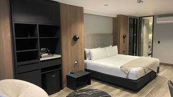Um quarto moderno com cama, escrivaninha, cadeira e mesa redonda.