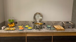 A buffet setup with various food items and a toaster. - HOTEL SELIS (Medellín)