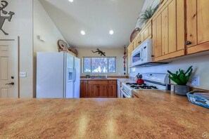Enjoy cooking in this well-equipped kitchen with a refrigerator, microwave, stove, and sink.