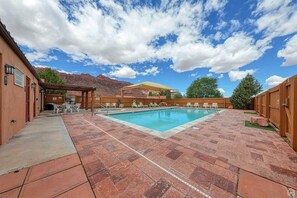 Relax by the pool surrounded by a mountainous landscape.