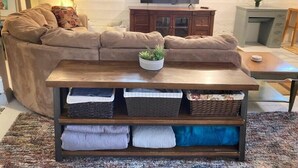 A living room with a sectional sofa, a coffee table, a TV, and a fireplace. - Centrally located, family and furry friendly fun! (Yakima)