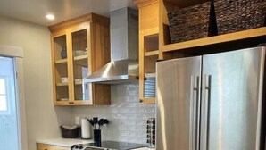 A modern kitchen with wooden cabinets, stainless steel appliances, and a tiled backsplash. - Centrally located, family and furry friendly fun! (Yakima)