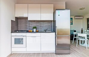 Enjoy cooking in this well-equipped kitchen with sleek cabinetry, a refrigerator, and oven.