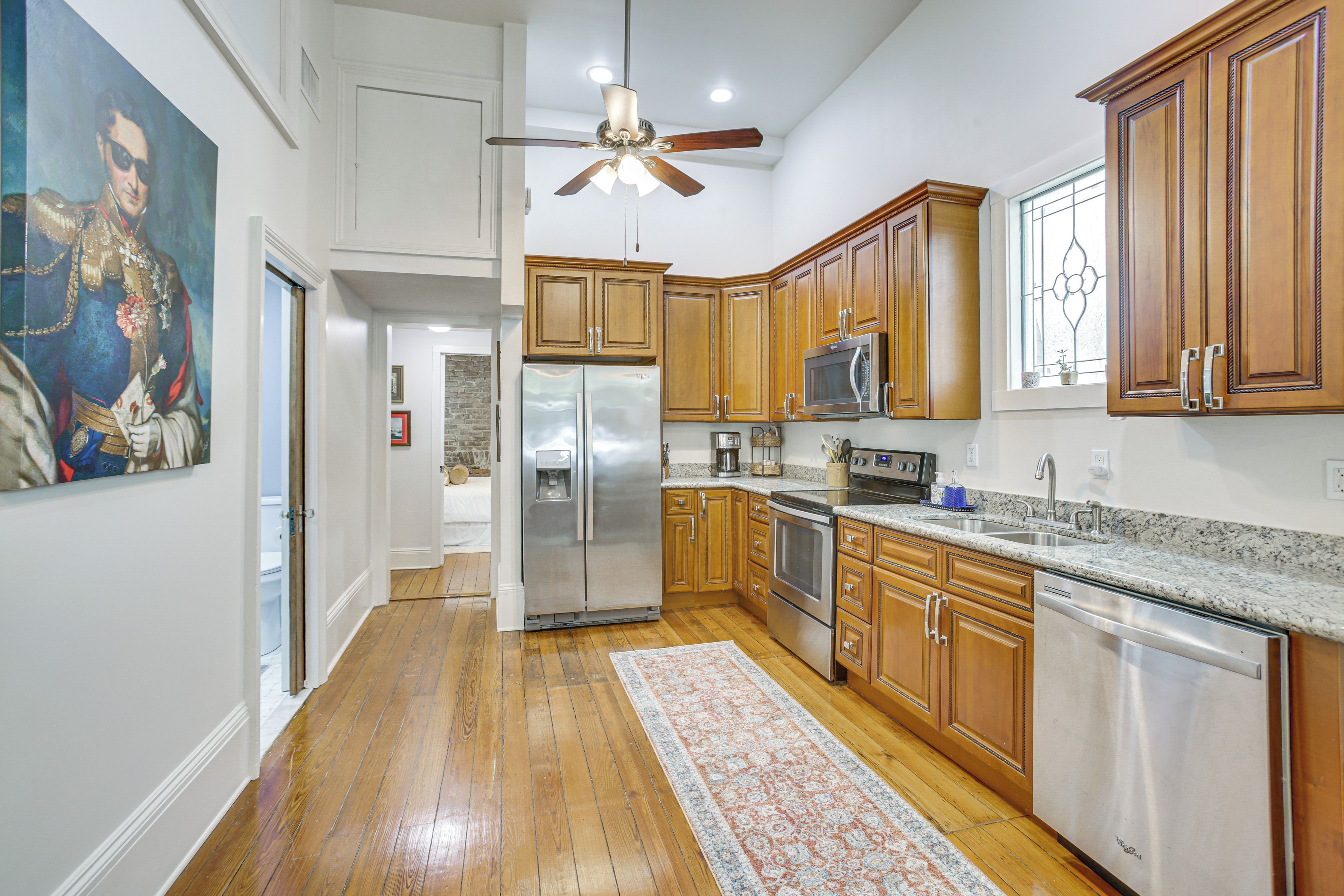 A kitchen with wooden cabinets, stainless steel appliances, and a granite countertop.