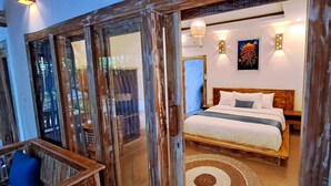 A bedroom with a wooden bed, a large window, and a wall-mounted light fixture.
