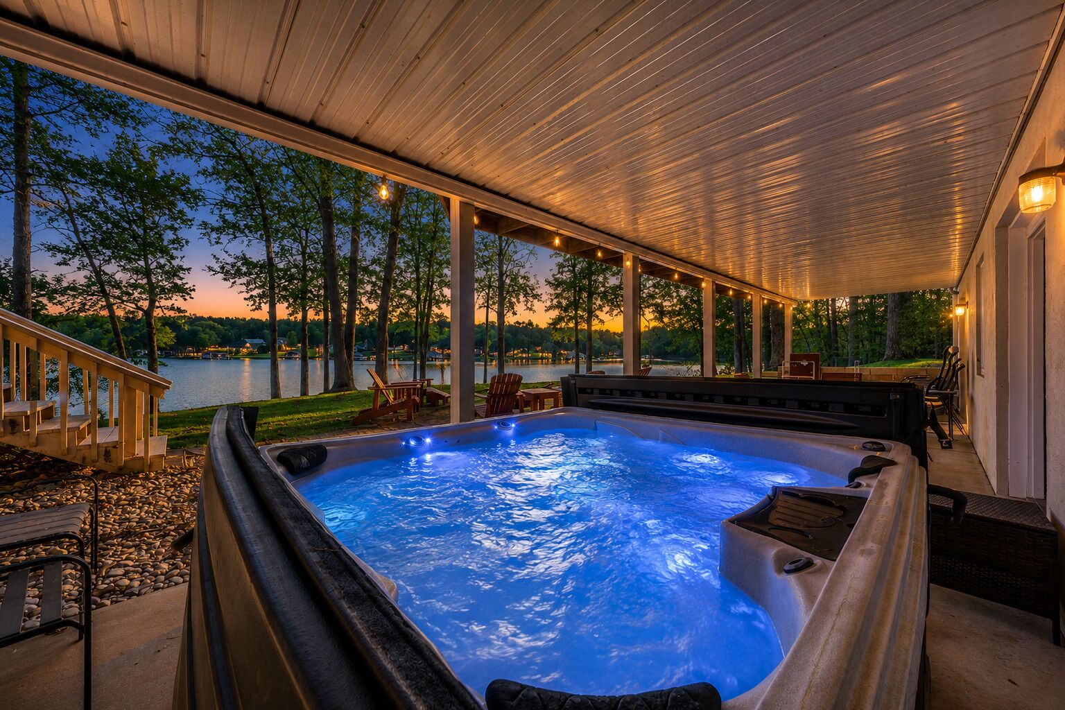 A hot tub with a view of a lake at dusk.