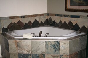 Une salle de bain avec une baignoire sur pieds, une serviette et un lavabo équipé de deux robinets.