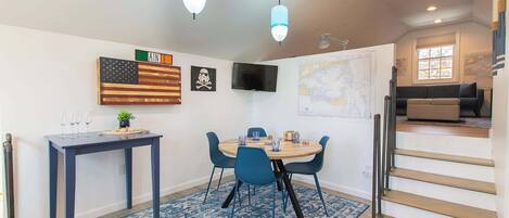 A dining area with a table, chairs, and a map on the wall.
