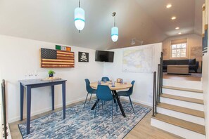 Un espace repas comprenant une table, des chaises et une carte accrochée au mur.