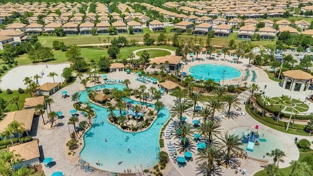 Een resort met meerdere zwembaden, ligbedden en palmbomen.