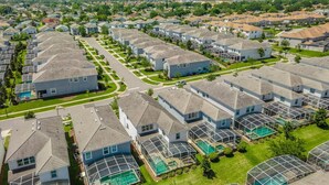 Een woonwijk met moderne huizen, een centrale weg en een zwembadgedeelte.