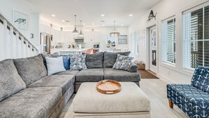 A modern living room with a grey sectional sofa, a wooden tray table, and a patterned armchair.
