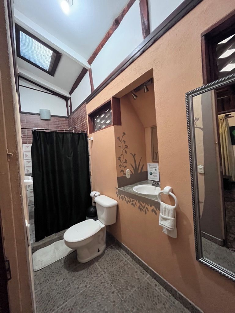 A compact bathroom with a toilet, sink, and shower area.