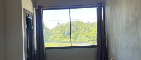 Una habitación con un ventanal amplio, un sofá y una puerta.