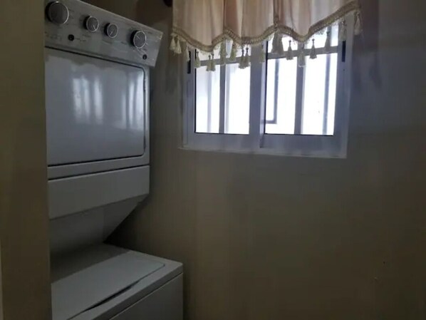 Una sala de lavandería con horno y ventana.