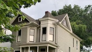A two-story house with a front porch, a chimney, and a well-maintained lawn. - A Room Off Broadway, a prime downtown hideaway (Bardstown)