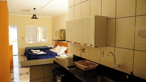 Een hotelkamer met een bed, een kleine kitchenette, een badkamer en uitzicht.
