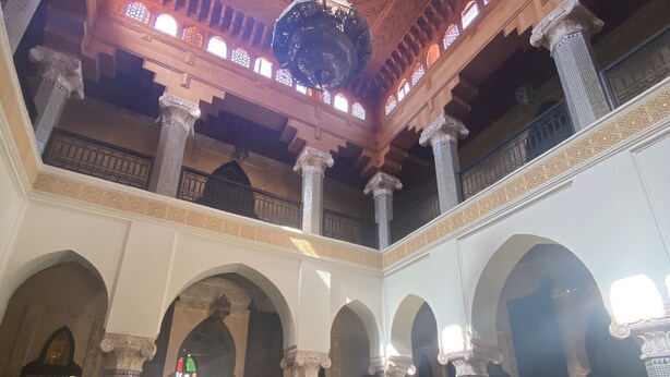 Un intérieur agrémenté d’une fontaine, d’un espace salon et d’un haut plafond soutenu par des colonnes.