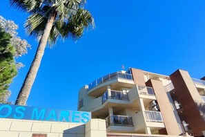 A multi-story building with balconies and a sign that reads 'OS MARES'.