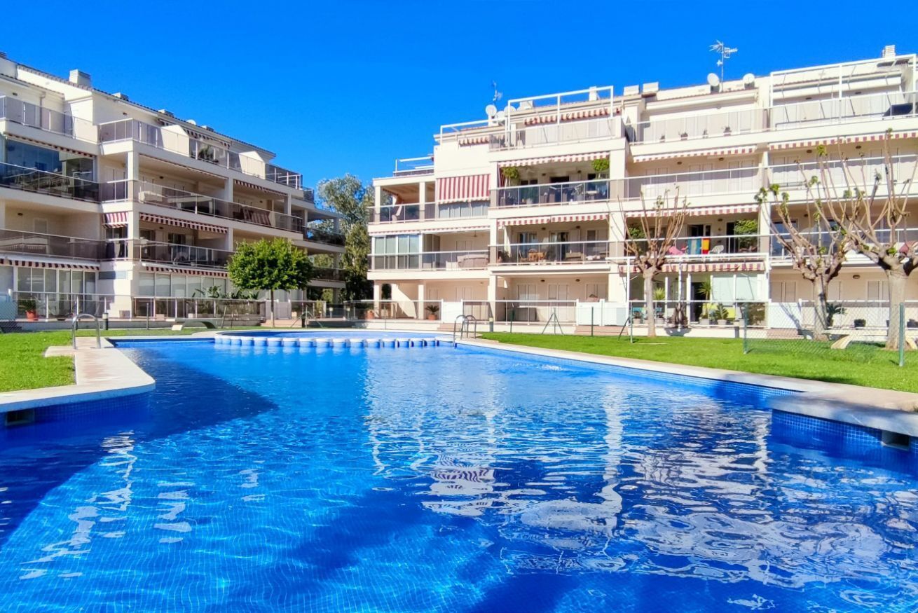 A swimming pool surrounded by multi-story buildings with balconies.