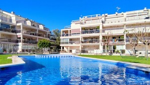 A swimming pool surrounded by multi-story buildings with balconies. - Apartament Los Mares by DENIA COSTA (Dénia)