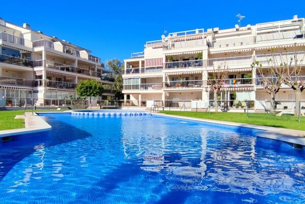 A swimming pool surrounded by multi-story buildings with balconies.