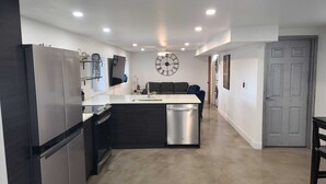 Una cucina moderna con isola centrale, elettrodomestici in acciaio inossidabile e lavastoviglie integrata.