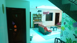 Ein Zimmer mit Bett, Bücherregal, Schreibtisch und einer Treppe.