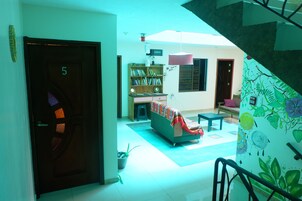 Una habitación con una cama, una estantería, un escritorio y una escalera.