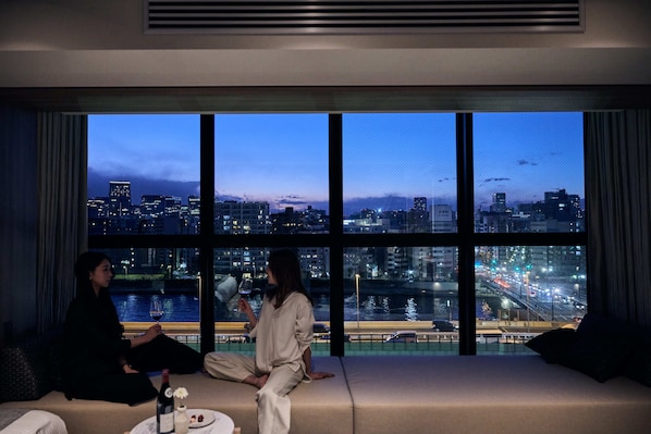 A room with a large window overlooking a cityscape at dusk. - fav TOKYO RYOGOKU (Tokyo)