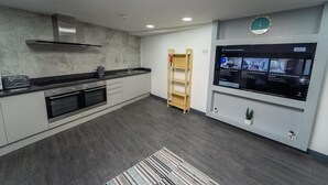 Una cocina moderna con horno empotrado, microondas y cafetera sobre la encimera.