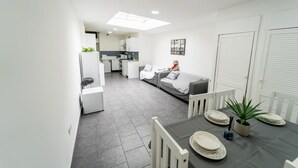 A modern apartment with a dining area, kitchen, and living room. - Large studio 10 minute train journey to the city! (Birmingham)