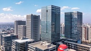 A high-rise urban area with modern glass buildings and a distinctive red dome structure. - Wyndham Guangzhou Baiyun Mountain (Guangzhou)