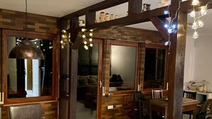 A dining area with a table, chairs, and a modern pendant light. - Holiday Home 'Balke' with Mountain View, Garden, Terrace & Wi-Fi (Hatzfeld)