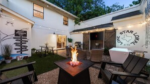 A backyard with a fire pit, outdoor seating, and a wall with directional signs. - Wine Trail Retreat w/ Fire Pit, Cold Plunge, Grill, Walk to Downtown JC! (Johnson City)
