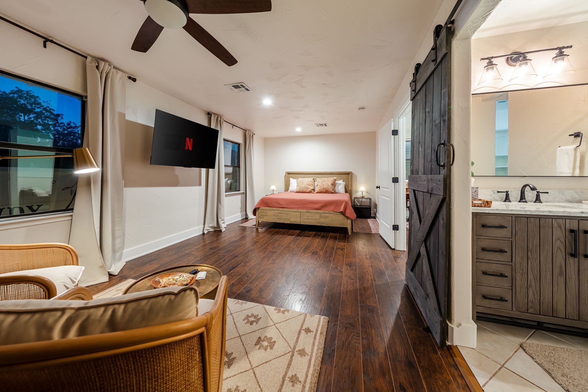 Master bedroom with 55 inch Roku TV and sitting area, with en suite bathroom.