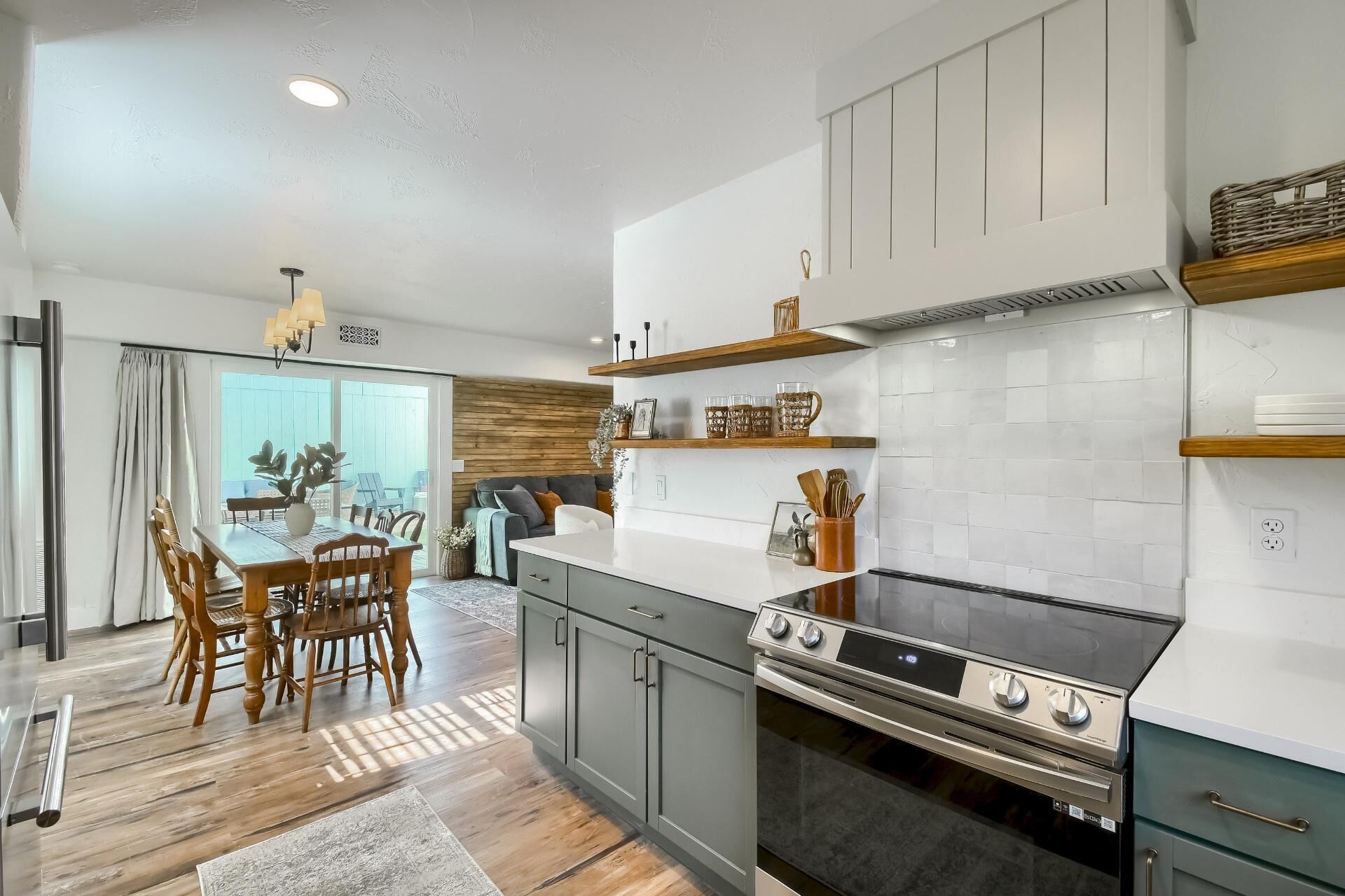 Una cocina moderna con estufa a gas, armarios de madera y un comedor con mesa y sillas.
