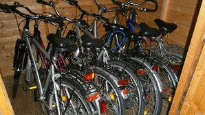 Une rangée de vélos est garée à l’intérieur d’une structure en bois.