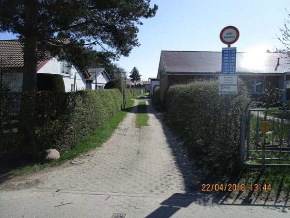 A narrow paved path flanked by hedges and residential buildings, with a no parking sign and a private property notice visible. - 45-square-meter Apartment (A) in the "Seebriese" vacation home. (Rostock)