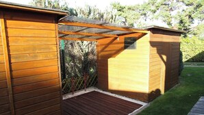 Un abri en bois avec un toit en pente et une terrasse en bois.