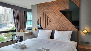 A modern hotel room with a large bed, two pillows, a nightstand, a desk, and a view of the city. - S3 Siam Bangkok (Bangkok)