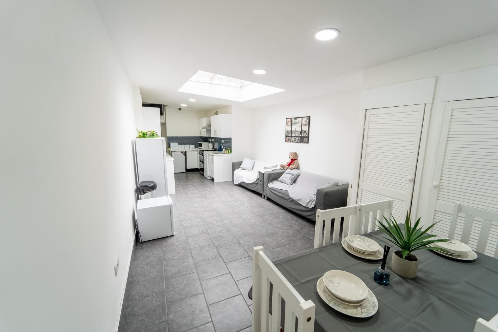 A modern apartment with a dining area, kitchen, and living room.