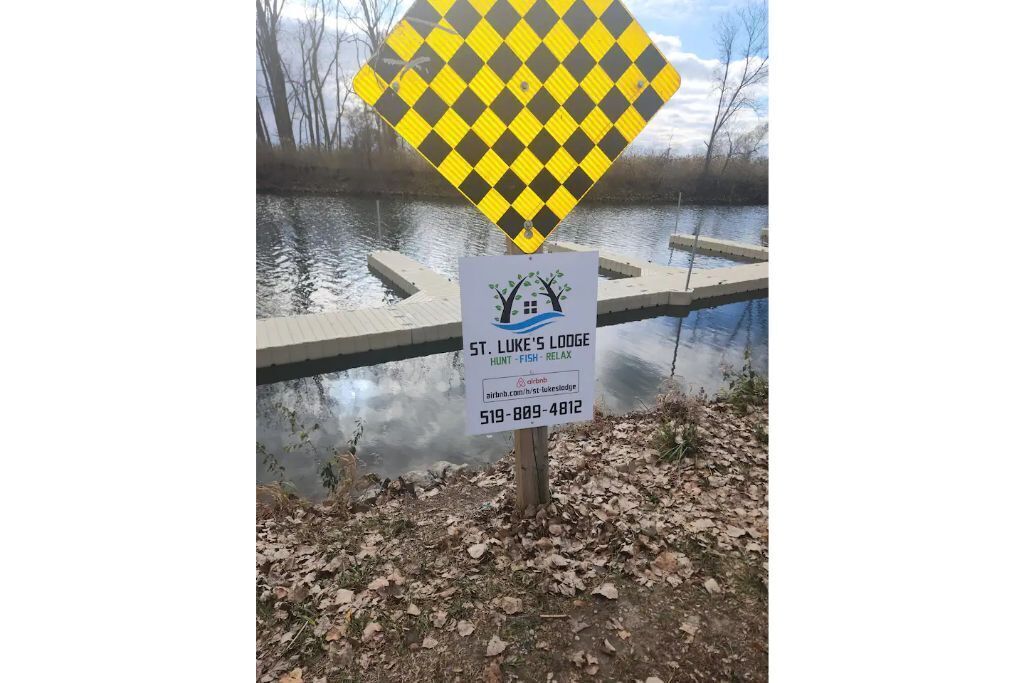 A sign for St. Luke's Lodge with a contact number and a website.